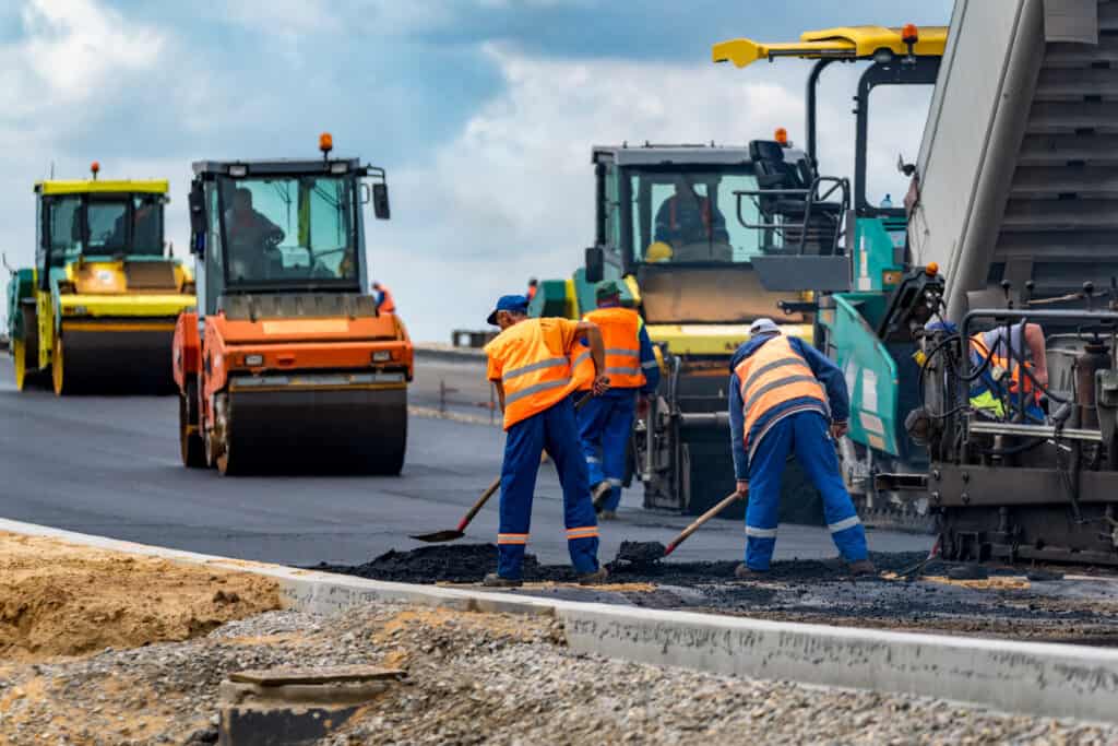 Los trabajadores y las máquinas asfaltadoras