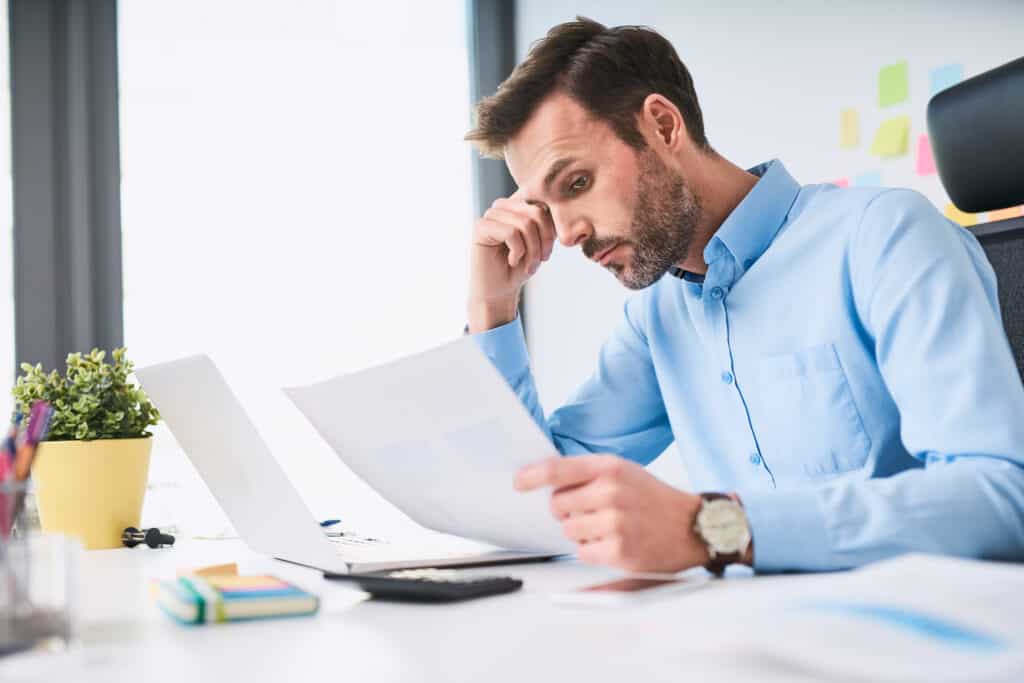 Unhappy Businessman Doing Paperwork At Office
