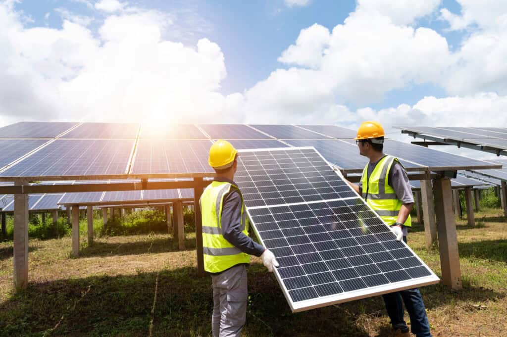 Two workers installing solar panels.