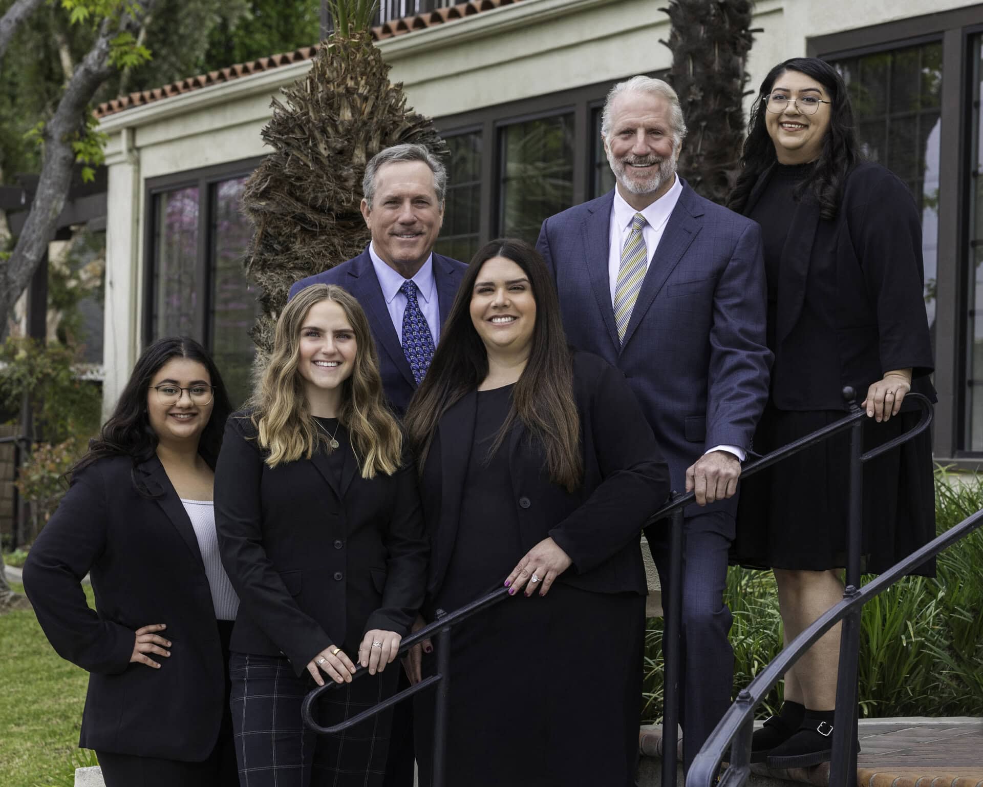 Donahoo Team Photo Donahoo & Associates attorneys and staff posing for a team photo on the stairs in front of their legal office.