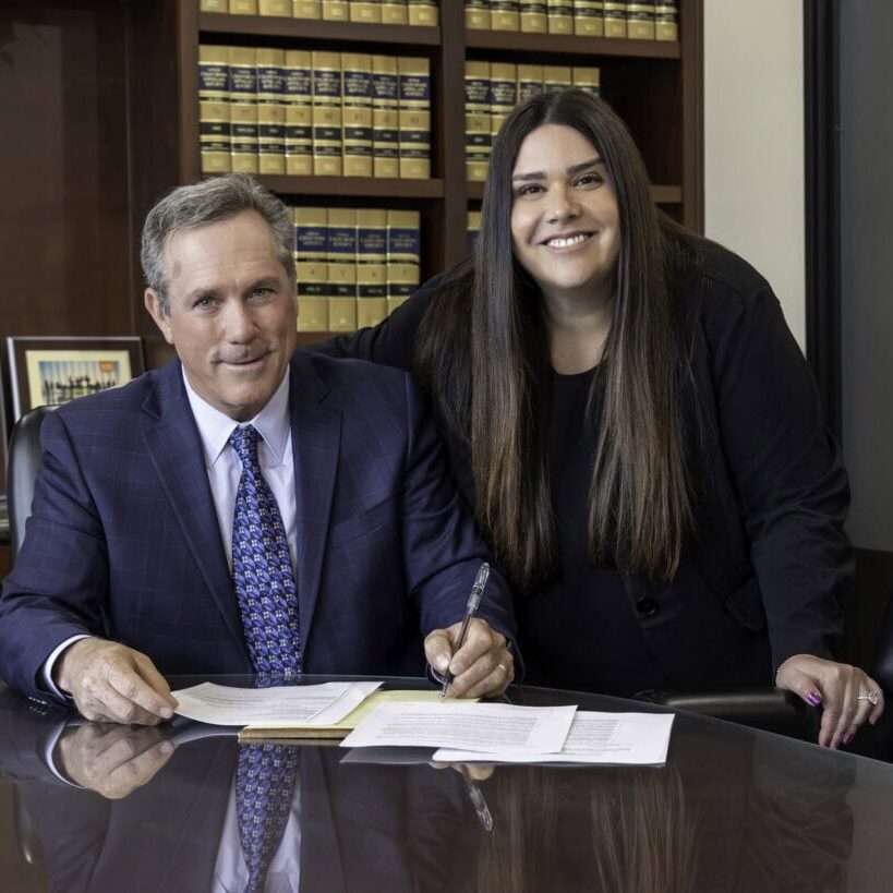 William Donahoo and Sarah L. Kokonas working at their office conference table.